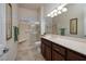 Bright bathroom featuring a walk-in shower with a seat, dark wood vanity, and a large mirror for added convenience at 2752 Fort Myer Ave, Henderson, NV 89052