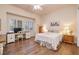 Cozy bedroom featuring wood floors, a plush bed, a window, and a dedicated workspace with desk and chair at 2752 Fort Myer Ave, Henderson, NV 89052