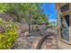 Backyard features gravel beds, lush greenery, and mature trees creating a serene and natural setting at 2805 Hanging Rock Dr, Las Vegas, NV 89134
