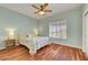 Comfortable bedroom with light walls, hardwood floors, a ceiling fan, and natural light through window shutters at 2805 Hanging Rock Dr, Las Vegas, NV 89134