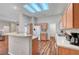 Contemporary kitchen with a breakfast bar, white appliances, and wood-look flooring in an open-concept layout at 2805 Hanging Rock Dr, Las Vegas, NV 89134