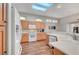 Open-concept kitchen featuring stainless steel appliances, skylights, a breakfast bar, and wood-look flooring at 2805 Hanging Rock Dr, Las Vegas, NV 89134