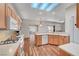 Bright kitchen featuring light wood cabinets, skylights, wood-look flooring, and an open floor plan at 2805 Hanging Rock Dr, Las Vegas, NV 89134
