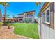 Sprawling backyard with synthetic grass, mature trees, and covered outdoor kitchen at 2820 Sisteron Ct, Henderson, NV 89044