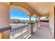 Balcony with wrought iron railing overlooks a home-lined street and mountains at 2820 Sisteron Ct, Henderson, NV 89044