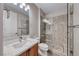 Bathroom features a glass-enclosed shower, wood cabinets, and stone floors at 2820 Sisteron Ct, Henderson, NV 89044