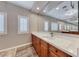 Bathroom showcasing wood cabinets, marble countertops, decorative lighting and tile flooring at 2820 Sisteron Ct, Henderson, NV 89044
