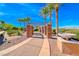 Scenic community pathway with stone pillars, desert landscaping, and palm trees under a clear blue sky at 2820 Sisteron Ct, Henderson, NV 89044
