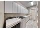 Bright laundry room features a sink, white cabinetry, washer, and dryer at 2820 Sisteron Ct, Henderson, NV 89044