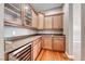 Walk-in pantry with custom cabinets, granite countertops, a wine refrigerator, and hardwood floors at 2820 Sisteron Ct, Henderson, NV 89044