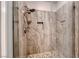 A glass-enclosed shower is tiled in light neutral colors and has river rock flooring at 2820 Sisteron Ct, Henderson, NV 89044