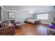 Spacious bedroom boasts hardwood floors, a crystal chandelier, and a cozy sitting area with couch and footstool at 3617 Dutch Valley Dr, Las Vegas, NV 89147