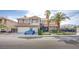 Two-story house boasts an attached two-car garage, mature palm trees, and beautiful architectural details at 3617 Dutch Valley Dr, Las Vegas, NV 89147