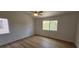 A spacious bedroom featuring wood floors, a ceiling fan, and natural light from two windows at 3750 Morning Canyon St, Las Vegas, NV 89147