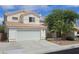 Exterior view of white home with two-car garage, tile roof and desert landscaping at 3750 Morning Canyon St, Las Vegas, NV 89147