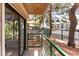 Exterior balcony features sliding glass doors, a green metal railing, and mature trees at 440 Elm Dr # 103, Las Vegas, NV 89169