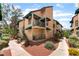 Tan two-story condos feature lush landscaping, green awnings, balconies, and walkway access at 440 Elm Dr # 103, Las Vegas, NV 89169