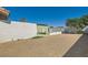 Wide backyard view showcases the perimeter wall, stone ground cover, a storage shed, and various trees and greenery at 445 Concord Way, Henderson, NV 89015