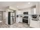 Modern kitchen with stainless steel appliances, white cabinets, and wood-style flooring at 445 Concord Way, Henderson, NV 89015