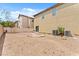 Backyard with minimal landscaping, a fence, and the house's exterior with a sliding door at 4858 Longshot Dr, Las Vegas, NV 89122