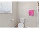 Cozy bathroom with toilet, towel rack, and window with blinds for privacy at 4858 Longshot Dr, Las Vegas, NV 89122