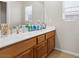 Bright bathroom featuring a double vanity with wood cabinets and large mirror at 4858 Longshot Dr, Las Vegas, NV 89122
