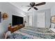 Bedroom with a ceiling fan, a large TV, and a window for natural light at 4858 Longshot Dr, Las Vegas, NV 89122