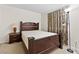 Bedroom with a dark wood frame bed, curtains, and bedside table with lamp at 4858 Longshot Dr, Las Vegas, NV 89122