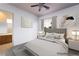 This staged bedroom offers neutral tones, soft textures, contemporary art, and a ceiling fan at 5210 Villa Dante Ave, Las Vegas, NV 89141