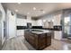 Bright, open kitchen with granite countertops, stainless appliances, a large island, and sleek wood flooring at 5210 Villa Dante Ave, Las Vegas, NV 89141