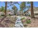 Exterior view of charming condominium buildings with lush landscaping, walkways, and mature trees at 5241 Caspian Springs Dr # 203, Las Vegas, NV 89120