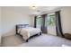 A bedroom showcasing a bed, large windows with gray curtains, and neutral colored walls at 529 Caribbean Palm Dr, Las Vegas, NV 89138