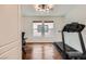 Bright bedroom with wood floors, two windows, and a treadmill for a home gym at 529 Caribbean Palm Dr, Las Vegas, NV 89138