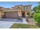 Inviting two-story home featuring a well-kept lawn, covered entrance, and two-car garage at 529 Caribbean Palm Dr, Las Vegas, NV 89138