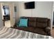 Bedroom features a comfortable brown couch and mounted TV, creating a relaxing space at 5576 W Rochelle Ave # 13A, Las Vegas, NV 89103