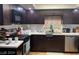 Kitchen features dark wood cabinets, stainless steel appliances, and stylish backsplash at 5576 W Rochelle Ave # 13A, Las Vegas, NV 89103