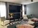 Living room with dark accent wall, oversized television, elegant fireplace, and sophisticated decor at 5576 W Rochelle Ave # 13A, Las Vegas, NV 89103