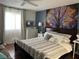 Comfortable main bedroom with an eye-catching tree art feature and ceiling fan at 5576 W Rochelle Ave # 13A, Las Vegas, NV 89103