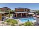 A backyard oasis with a pool, outdoor kitchen, covered patio, and mature landscaping at 5635 Mesa Mountain Dr, Las Vegas, NV 89135