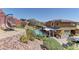 Stunning backyard view featuring a pool, covered patio, and terraced landscaping at 5635 Mesa Mountain Dr, Las Vegas, NV 89135