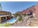 The backyard features a sparkling pool, lounging area, and landscaped terraced hillside at 5635 Mesa Mountain Dr, Las Vegas, NV 89135