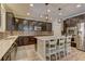 Bright, open kitchen featuring dark cabinets, a center island with seating, and stainless appliances at 5635 Mesa Mountain Dr, Las Vegas, NV 89135