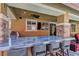Stylish outdoor bar with granite countertop and seating, overlooking the patio and backyard at 5635 Mesa Mountain Dr, Las Vegas, NV 89135