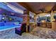 Outdoor kitchen and covered patio with a built-in grill and refrigerator, plus seating overlooking the pool and landscaped yard at 5635 Mesa Mountain Dr, Las Vegas, NV 89135