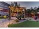 Charming pergola with string lights, complemented by lush landscaping and a stone pathway, creating an inviting outdoor retreat at 5635 Mesa Mountain Dr, Las Vegas, NV 89135