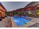 Sparkling swimming pool and spa surrounded by lush landscaping, an outdoor TV, and ample seating for relaxation at 5635 Mesa Mountain Dr, Las Vegas, NV 89135