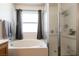 A soaking tub with tile surround and glass shower door featured in this bathroom at 5824 Kane Holly St, Las Vegas, NV 89130