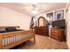This bedroom features a natural light, ceiling fan, and wood dresser with mirror at 5824 Kane Holly St, Las Vegas, NV 89130