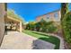 Backyard features brick pavers, artificial grass and a covered patio with ceiling fan at 5931 Allanche Ave, Las Vegas, NV 89141