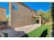 Two-story home featuring backyard with artificial grass and covered patio area at 5931 Allanche Ave, Las Vegas, NV 89141